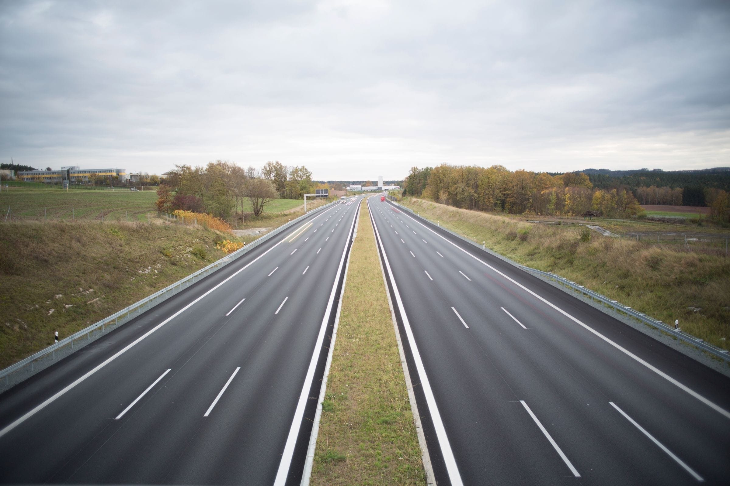 Towing Pekin IL: divided highway through open fields on an overcast day, the kind of road our trucks cover around Pekin