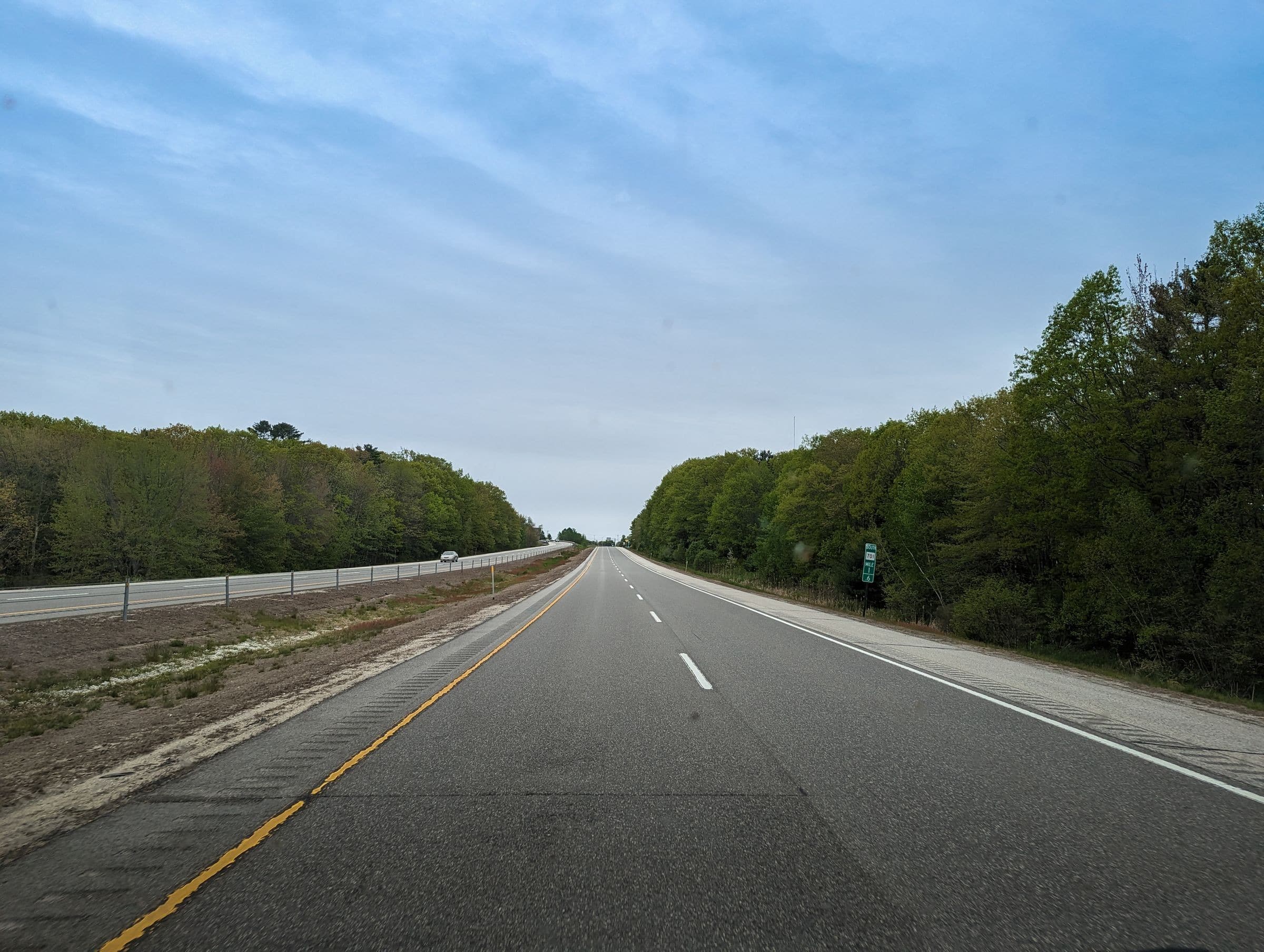 Two-lane highway through trees on an overcast day
